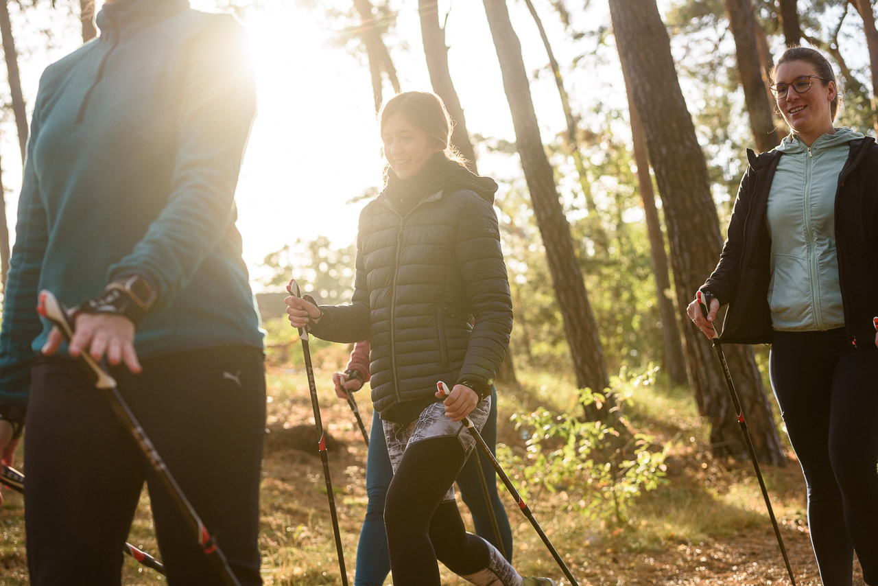 Frauen betreiben bei Sonnenschein Nordic Walking im Wald